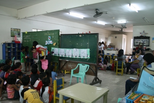 A movable blackboard divides the room into two: kindergarten class on the left side and nursery class on the right side of the room. 